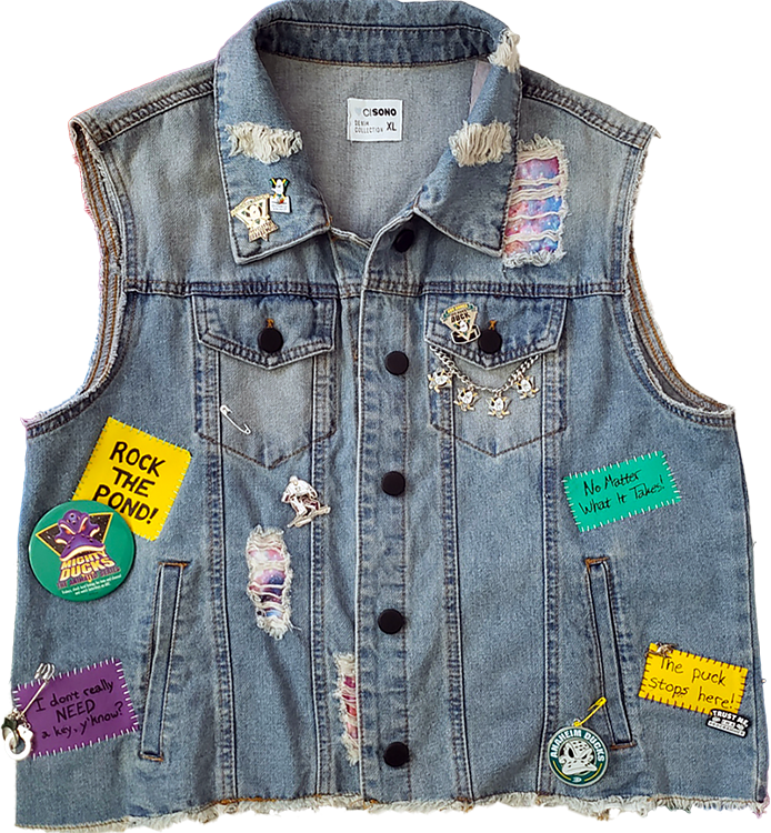 a distressed, light denim vest covered in pins and patches pertaining to the Mighty Ducks: The Animated Series cartoon, and the real-life team.