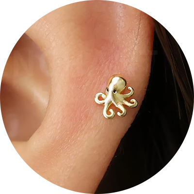 a silver ear stud that looks like a tiny octopus