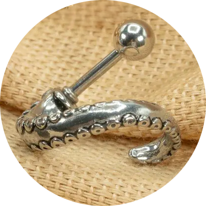 a silver barbell earring with an octopus tentacle coming off one end