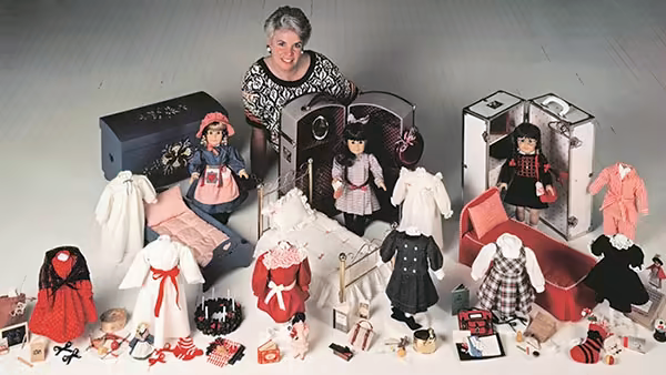 Pleasant Rowland posing with the first three dolls in the collection and their accessories